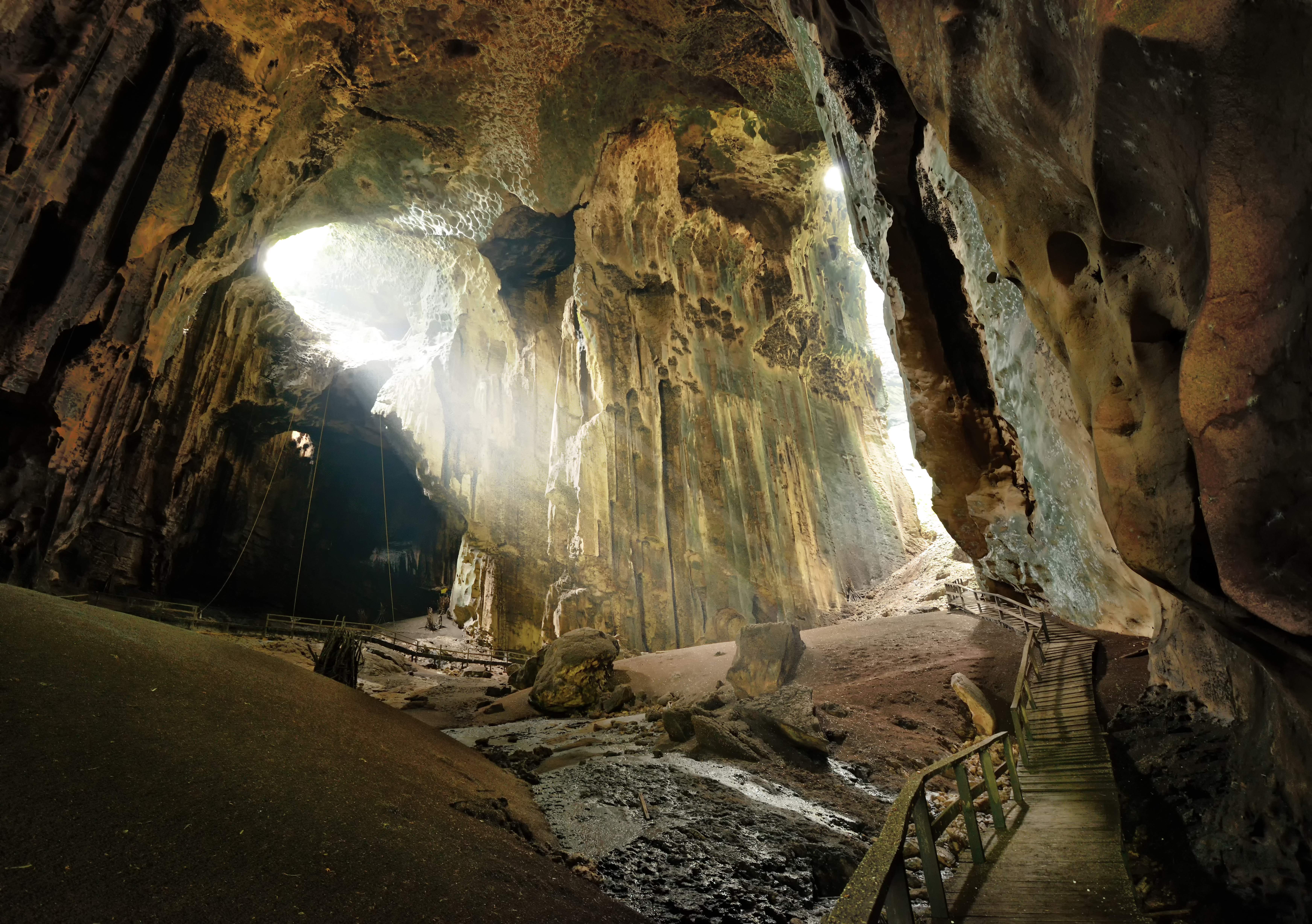 Visitors on the boardwalk inside Gomantong Caves with headtorches